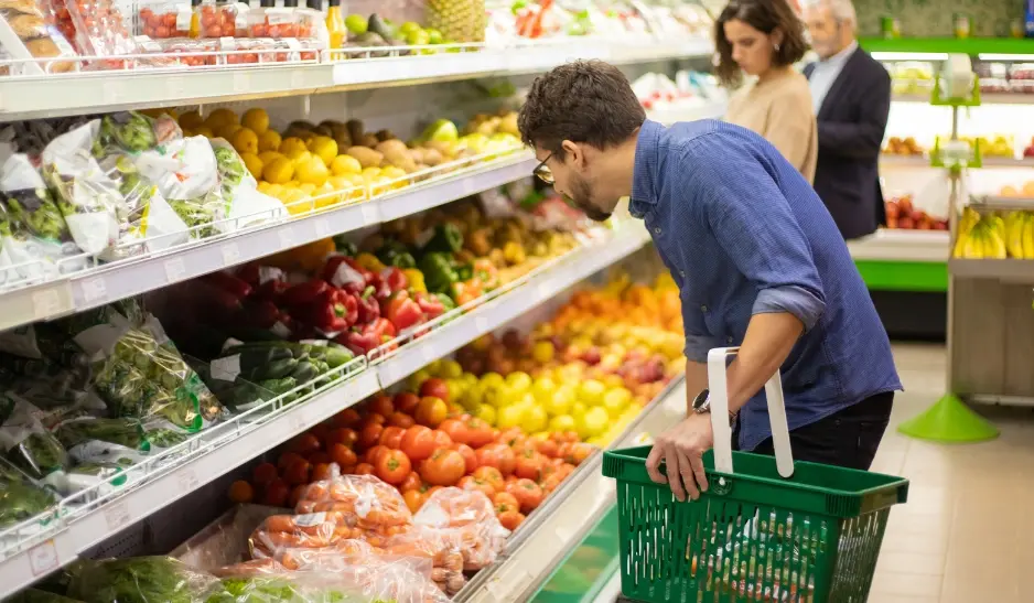 A man shopping fresh vegetables from a corner store